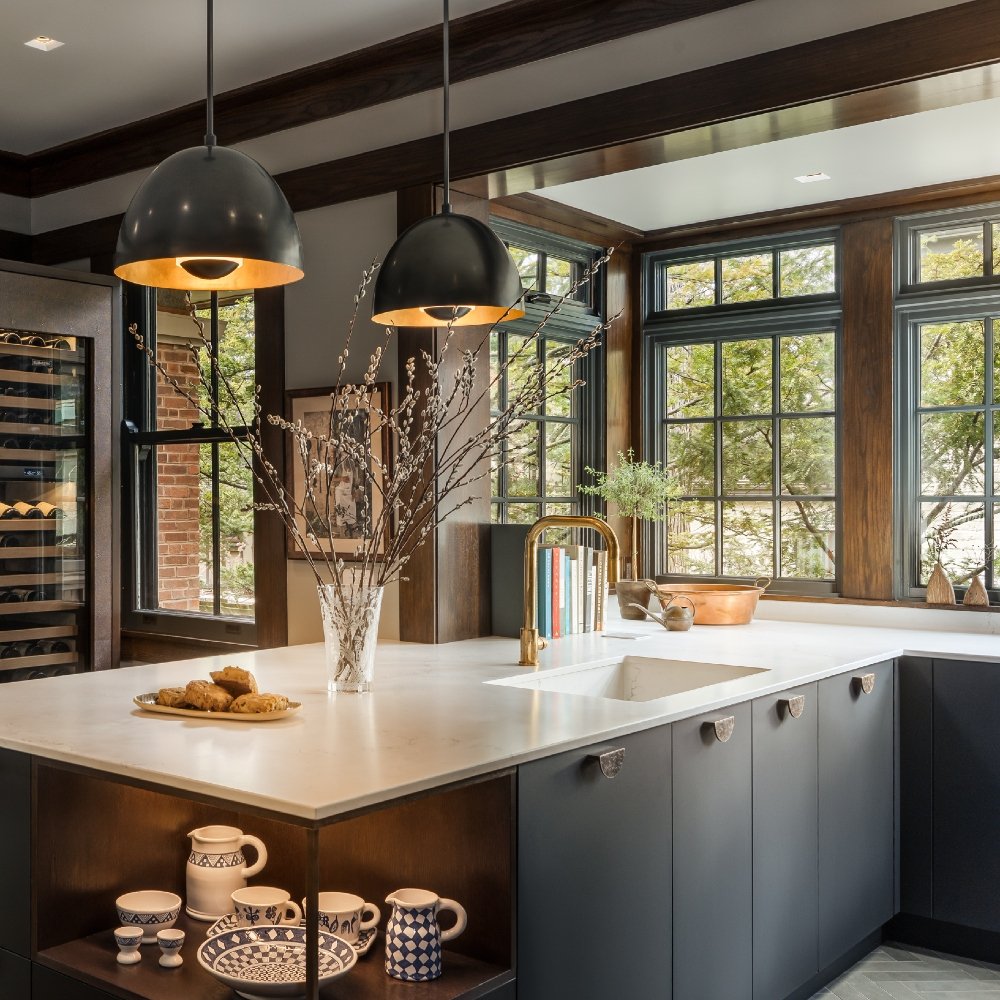 Homeowner enjoying remodeled kitchen with large island, new cabinets, and bright task lighting